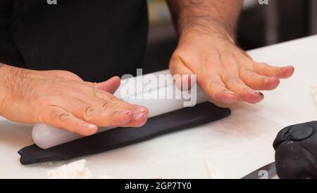 Gebäck Lektion, die auf Zahlen von Halloween mit Fondant einfügen oder Zuckerpaste. Stockfoto
