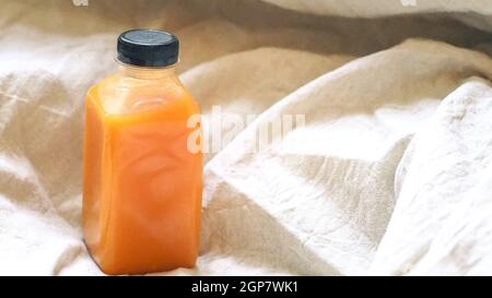 Orangensaft in einer Flasche auf Leinenhintergrund. Natürliche Konzept-Idee .Health-Idee Stockfoto