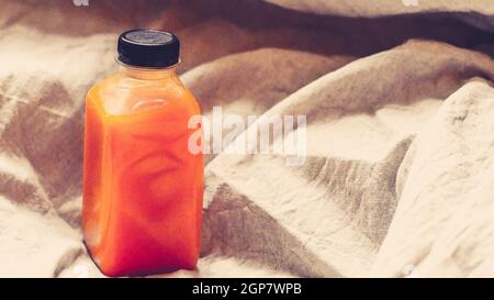 Orangensaft in einer Flasche auf Leinenhintergrund. Natürliche Konzept-Idee .Health-Idee Stockfoto