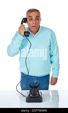 Angst Mann im Gespräch mit alten Bakelit Telefon auf weiß. Stockfoto