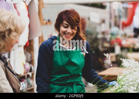 Zwei Floristen arbeiten in einem Kindergarten. Paar arbeiten in der Gärtnerei auf einem normalen Arbeitstag. Auf dem Foto eine blonde Frau und eine junge Frau mit r Stockfoto