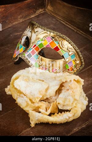 Typische frittiertes Gebäck der italienischen Karneval mit venezianische Maske. Diese süssen werden auf unterschiedliche Weise, chiacchiere, Galani, cenci oder Frappe genannt. Stockfoto