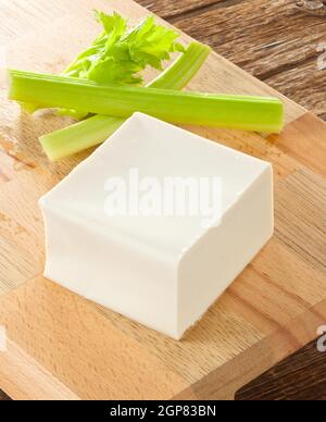 Frischer Tofu-Würfel auf Holzbrett. Stockfoto