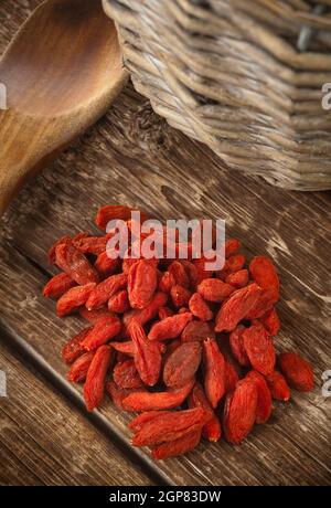Getrocknete Goji-Beeren isoliert auf Holztisch. Stockfoto