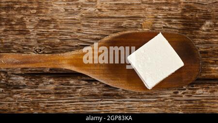 Frischer Tofu Cube in Holzlöffel auf Holztisch Stockfoto