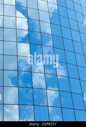 Modernes Glas Wolkenkratzern Hintergrund mit Himmel und Wolken Reflexion. Stockfoto