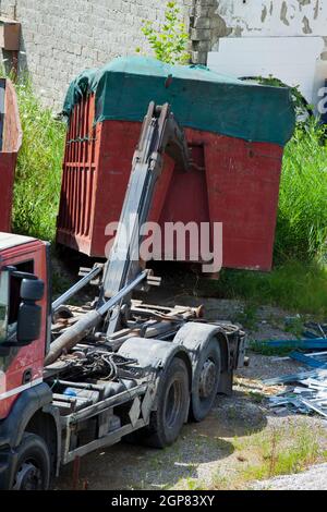 Anschließen eines vollen Containers auf dem LKW. Stockfoto