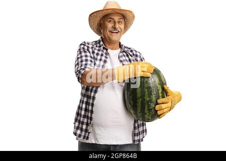 Fröhlicher Bauer mit einem Strohhut, der eine große Wassermelone auf weißem Hintergrund isoliert hält Stockfoto