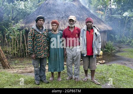 Papua-Neuguinea; Goroka; Katholische Missionsstation von Namta (Mefenga) unter der Leitung der Missionare der Heiligen Familie. Eine Gruppe von Papua vor einer Hütte. Stockfoto