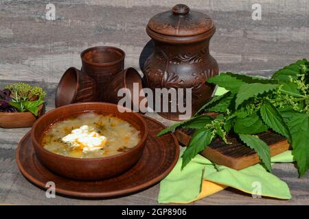 Suppe aus Sauerampfer und Brennnesseln auf dem rustikalen Tisch, Frühling Stockfoto