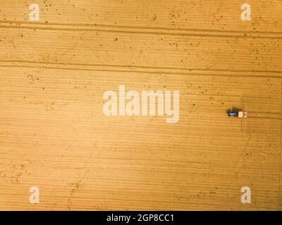 Traktor sprühen Ernten in Feld, Luftaufnahme von Drone pov Stockfoto