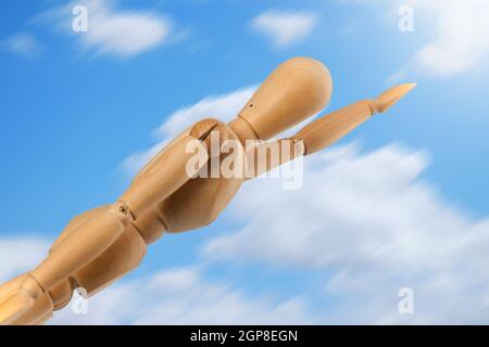 Dummy-Superheld im Flug auf blauer Himmel mit Wolken. Stockfoto