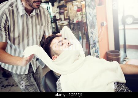 Traditionelles Ritual der Rasur des Bartes mit warmen und kalten Kompressen in einem alten Stil-Friseur. Stockfoto