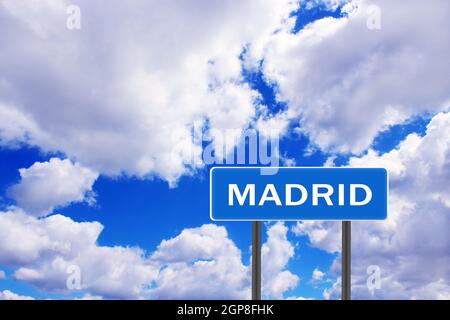 Schild mit Inschrift Madrid mit Blick auf den Himmel. Straßenschild mit Hinweis auf die Siedlung. Zeichen über Madrid auf blauem und bewölktem Himmel Hintergrund. Zeiger auf Th Stockfoto