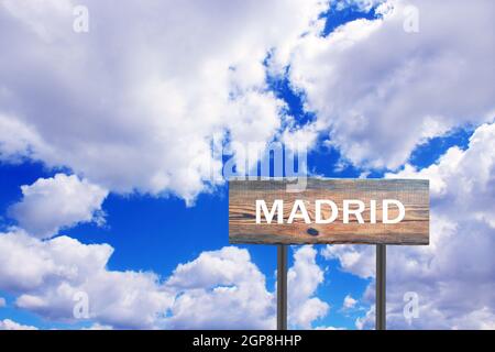 Schild mit Inschrift Madrid mit Blick auf den Himmel. Zeiger auf die Abrechnung. Straßenschild mit Hinweis auf Siedlung. Zeichen über Madrid auf blau und wolkig Himmel BA Stockfoto