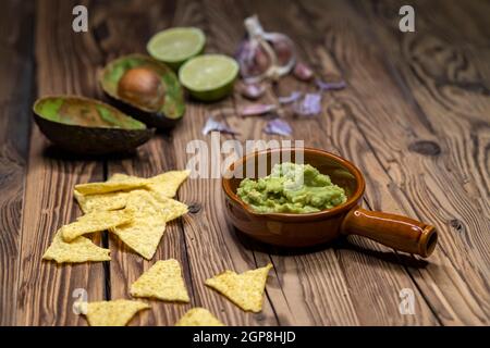 Avocado Dip mit Knoblauch, Chili, Pfeffer und Limettensaft mit Mais Nachos gewürzt Stockfoto