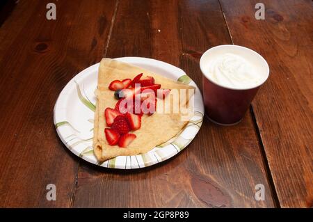 Ein köstliches Frühstück mit frischen Beeren und Schlagsahne auf Crepes Stockfoto