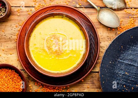 Teller mit vegetarischer roter Linsensuppe auf Holztisch Stockfoto