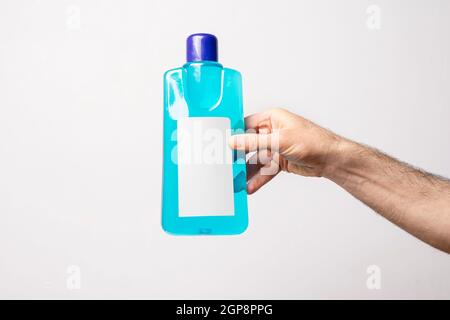 Hand hält einen Teppich Reinigung Flüssigkeit Flasche vor hellgrauem Hintergrund, editierbare Modell-up-Serie Vorlage bereit für Ihr Design, Label selectio Stockfoto