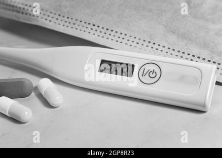 Mittel zur Behandlung und Prävention von Coronavirus-Infektionen: Medikamente, Gesichtsmaske und elektronisches Medizinthermometer zur Messung von Body tempe Stockfoto