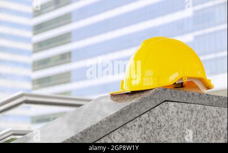 Gelber Schutzhelm auf Baustelle mit Bauhintergrund. Arbeitskonzept für Sicherheits- und Personenschutzgeräte. Stockfoto