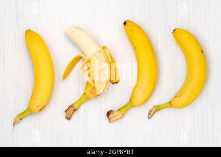 Vier Bananen auf Holztisch. Ansicht von oben. Stockfoto