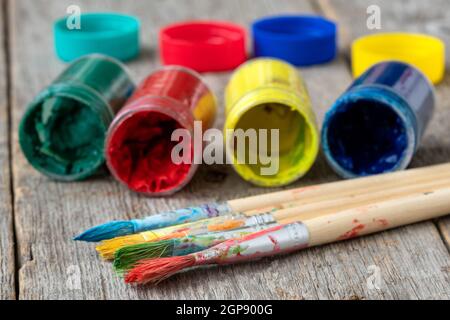 Pinsel und Gläser mit trockenen Gouache auf Holz- Hintergrund Stockfoto