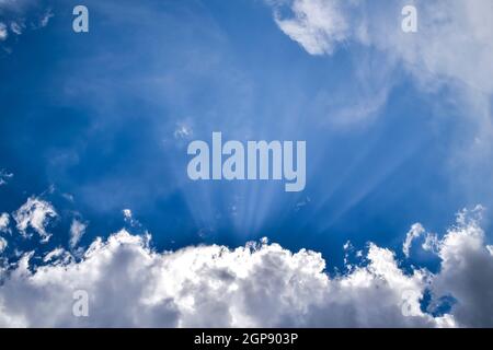 Sonnenstrahlen durch cumulus Wolken brechen. Himmlische Landschaft. Stockfoto