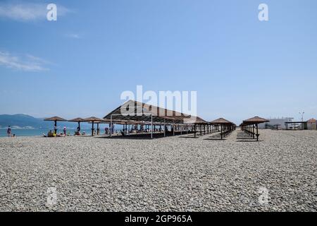 Noworossijsk, Russland - 20. Mai 2018: Strand Vordächer für Schutz vor der Sonne, der am Ufer des Meeres. Kiesstrand Aleksino in Noworossijsk. Stockfoto