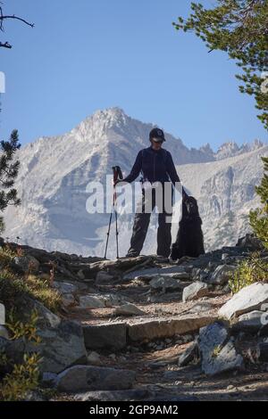 Frau, die mit einem Hund (gordon Setter) auf einem Bergpfad in den Sierra Nevada Mountains, Kalifornien, USA, wandert Stockfoto