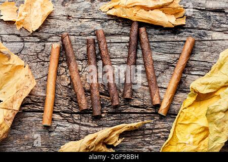 Zigarillos und trockenes Tabakblatt auf Holzhintergrund Stockfoto