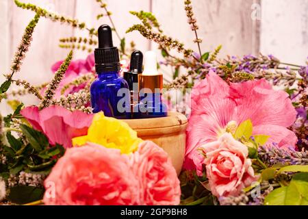 Blumen und Flaschen mit ätherischen Ölen für die Aromatherapie Stockfoto