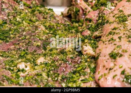 Rohes Fleisch mariniert in Knoblauch Olivenöl Petersilie Salz Pfeffer Stockfoto