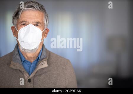 Älterer Mann mit Gesichtsbedeckung während des Coronavirus- und Grippeausbruchs. Schutz vor Viren und Krankheiten, Quarantäne zu Hause. COVID-19 Konzept Stockfoto