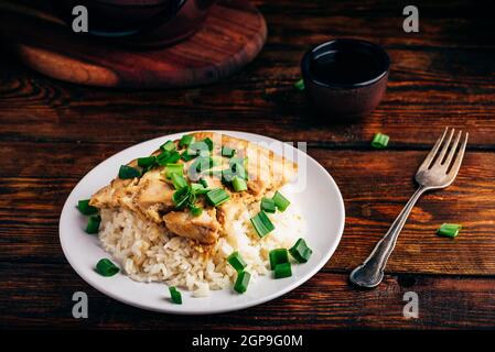 Weißer Reis mit Rührei mit Huhn und Frühlingszwiebeln auf Platte Stockfoto