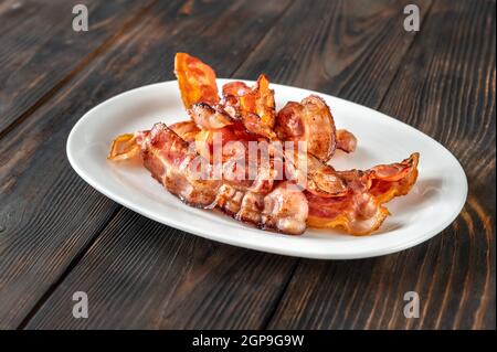 Gebratener Speck auf dem weißen Servierteller Stockfoto