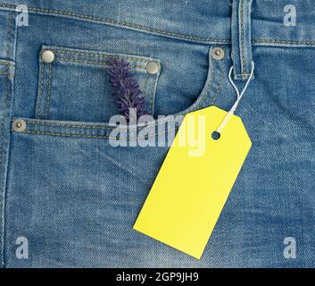 Unbeschriftete rechteckige Pappe gelbe Tag auf blaue Jeans Hintergrund, Nahaufnahme Stockfoto