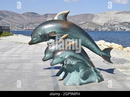 Die Bronze-Skulptur von drei Delphine am Strand. Stockfoto