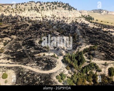 Wildfire-Überreste aus einem Hubschrauber der Nebraska Army National Guard UH-60 Blackhawk in der Nähe von Crawford, Nebr., 18. September 2021. Die Nationalgarde der Nebraska-Armee aktivierte 22 Soldaten, um vier Flugzeuge mit großen Wassereimern zur Unterstützung der Feuerwehrleute am Boden bereitzustellen, wobei sie zwei Waldbrände bekämpfte, die zusammen 8,000 Hektar Land verbrannten, bevor sie am 23. September eingedämmt wurden. (Foto mit freundlicher Genehmigung von Capt. Nathanael Rutherford) Stockfoto