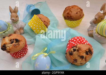 Osterdekoration gefärbte Eier, Muffins und Hase auf Holztisch Stockfoto