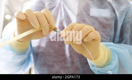 Die Hände des Arztes in den Schutzhandschuhen vor den Manipulationen der künstlichen Befruchtung. Reproduktionstechnologien. Das Problem der Schwangerschaft. Stockfoto