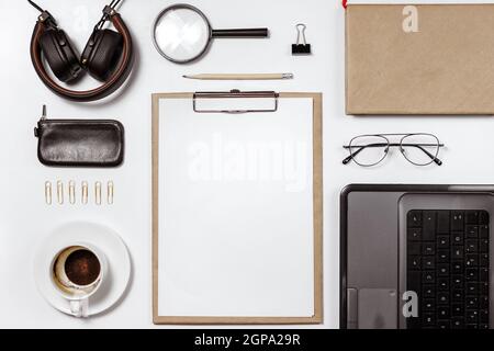 Flaches Lay von stilvollen männlichen Arbeitsplatz mit Clip-Ordner, Laptop und Business-Zubehör auf weißem Hintergrund. Speicherplatz kopieren Stockfoto