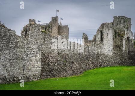 Zerstörte Mauern und Befestigungsanlagen von Trim Castle aus dem 12th. Jahrhundert mit dunklen launischen Himmel in Trim Dorf, County Meath, Irland Stockfoto