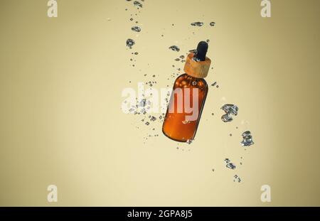 Flasche ätherisches Öl in Wasser auf farbigem Hintergrund Stockfoto