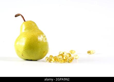 Vitamin Pillen Kapseln zusammen mit Birnenfrucht gesunde Ernährung Vitamin C gut für das Immunsystem freigesetzt Stockfoto