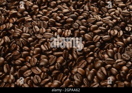 Eine Nahaufnahme von frisch gerösteten Kaffeebohnen, um einen Vollbildhintergrund zu erzeugen. Stockfoto