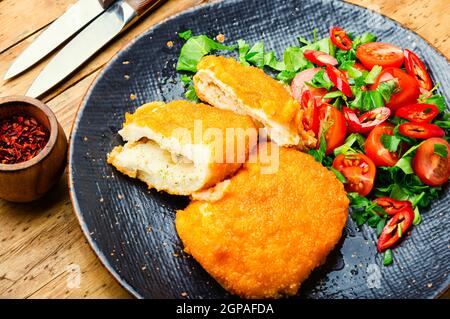 Chicken Kiev Cutlet mit frischem Gemüsesalat.Ukrainisches Essen Stockfoto