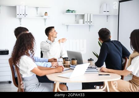 Mann im Rollstuhl, der im Büro vorgeführt wird Stockfoto
