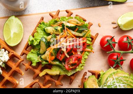 Köstliche belgische Waffeln mit Gemüse und Limette auf dem Tisch, Nahaufnahme Stockfoto
