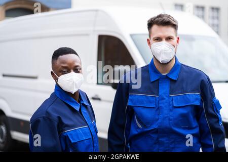 Elektriker Techniker Oder Klempner In Arbeitskleidung Und Gesichtsmaske In Der Nähe Van Stockfoto